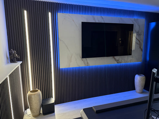 Modern interior design with a TV mounted on a PVC Marble Sheet, illuminated by LED lights inside Acoustic Wall Panels