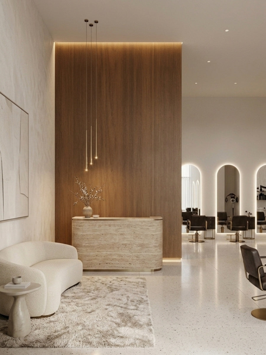 Walnut wood veneer panel reception wall with warm edge lighting behind a stone-front desk